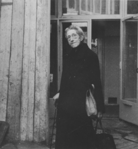 876758 Portret van een oude vrouw bij de voedseluitdeling door de Zusters Augustinessen van St.-Monica, vermoedelijk ...